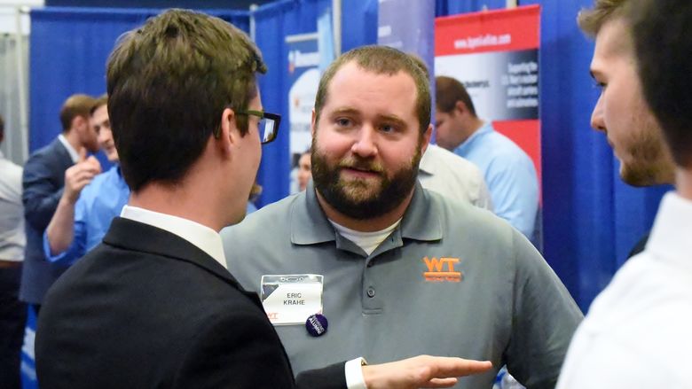 A recruiter talks with students at the Penn State Behrend fall Career and Internship Fair.