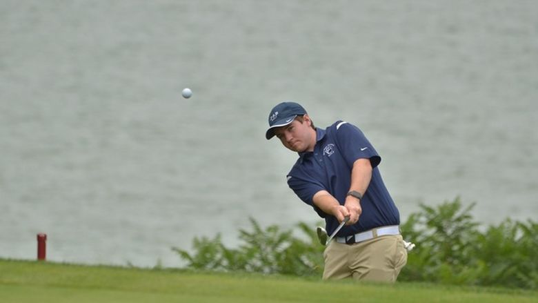 A Penn State Behrend golfer chips the ball onto the green.