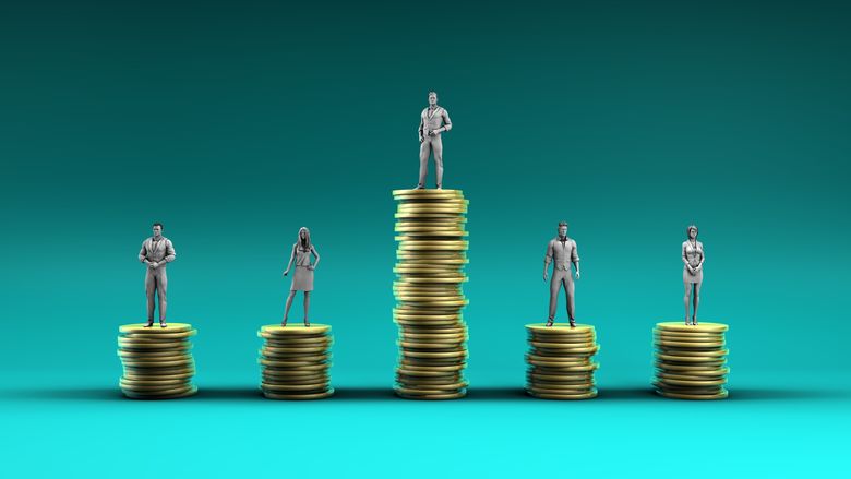 Figurines are posed on coins stacked to varying heights to illustrate the problem of economic inequality.