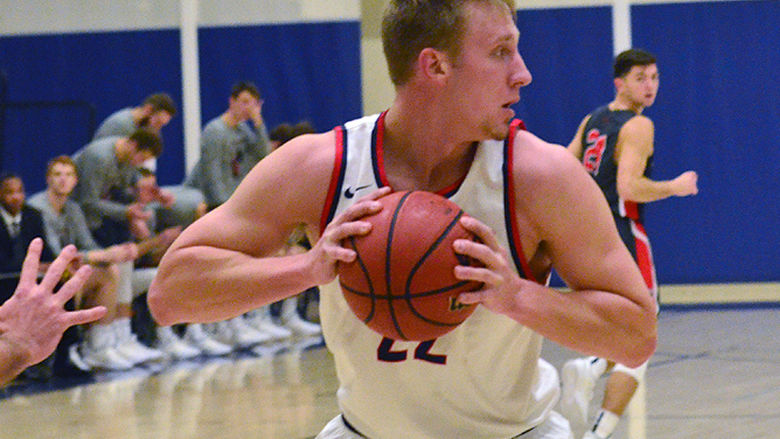 Penn State Behrend basketball player Justin Gorny prepares to pass the ball.