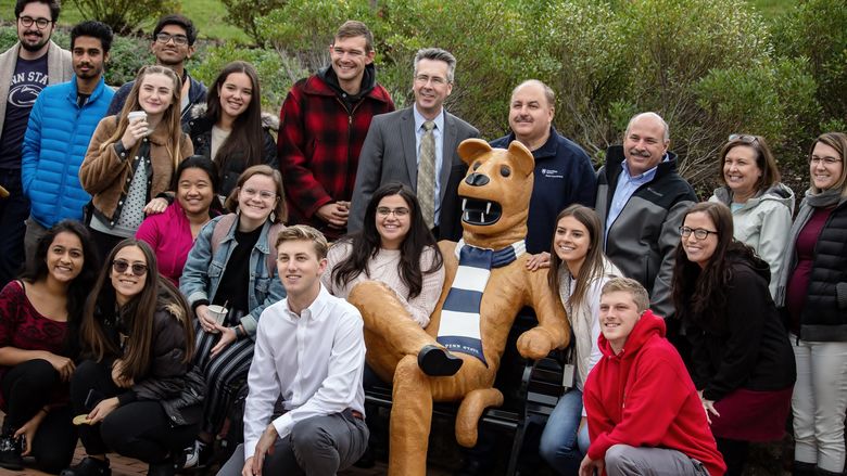 Students, faculty and staff pose at Penn State Behrend's new Nittany Lion bench.