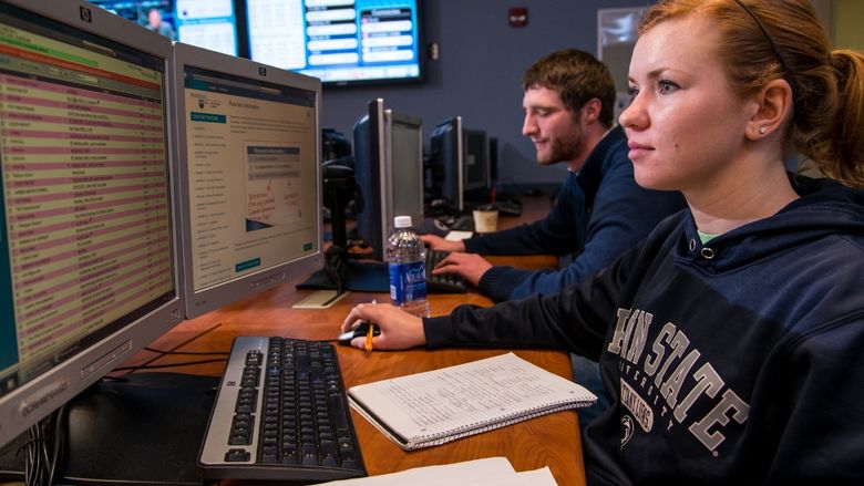 Two students work on computers in the financial trading lab at Penn State Behrend.