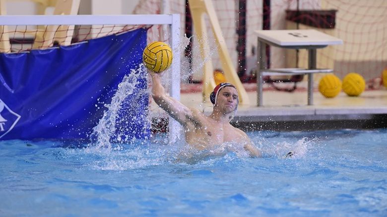 A Penn State Behrend water polo player throws the ball.