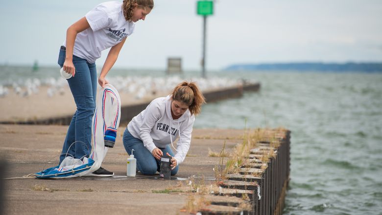 Two female students check a net after sampling Lake Erie for bloody red shrimp.