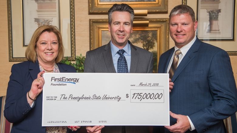 Three people hold a foundation check from the FirstEnergy Foundation.