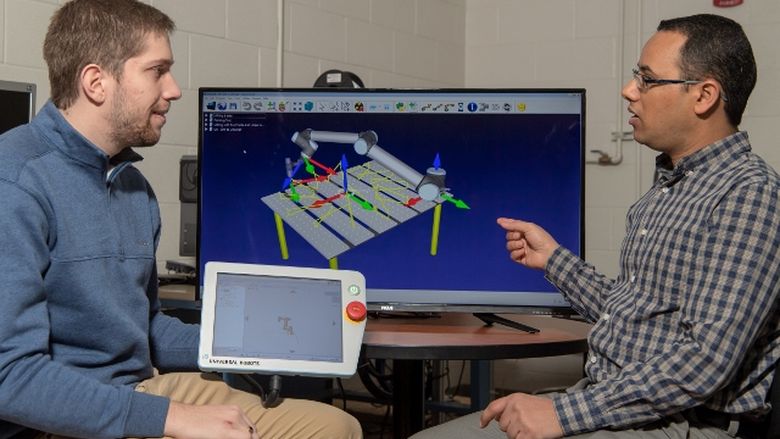 A Penn State Behrend faculty member uses a computer simulation while working with a student.