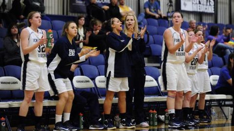 Players cheer during a Penn State Behrend women's basketball game.