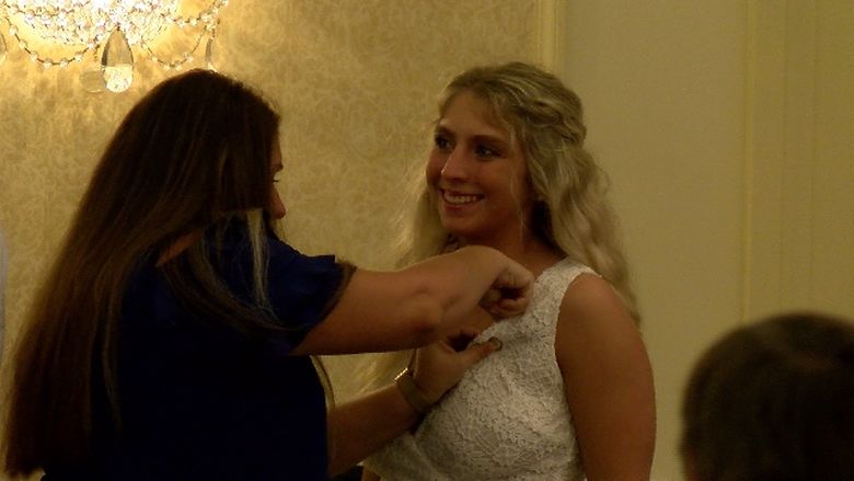 A graduate of Penn State Behrend's nursing program receives a pin at the college's annual pinning ceremony.
