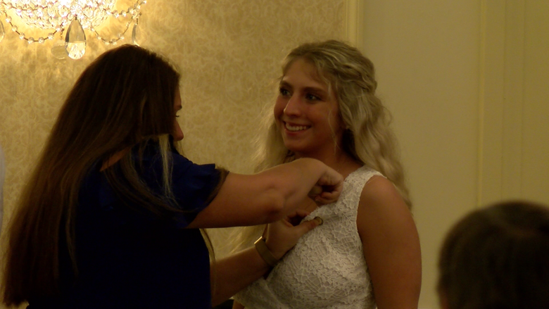 A Penn State Behrend nursing graduate receives a pin during the college's pinning ceremony.