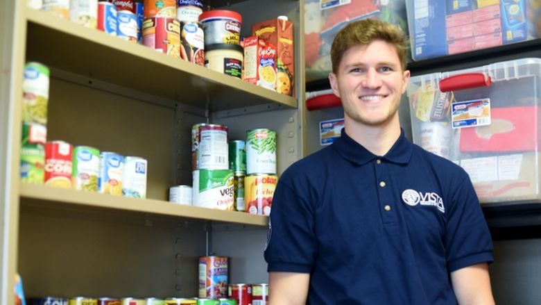 AmeriCorps VISTA member Rob Felger poses in the Lion's Pantry food pantry at Penn State Behrend.
