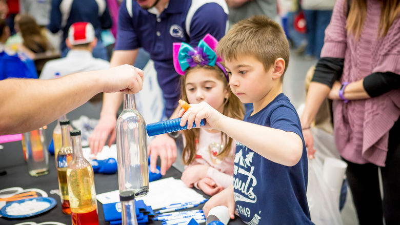 Children experiment with magnets and glass at the Penn State Behrend STEAM fair.