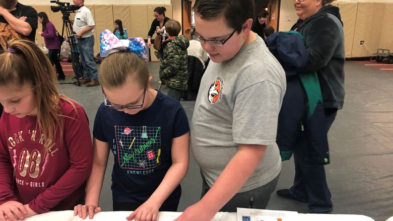 Gavin Williams, right, and Emma Williams work to build a cost-effective pipeline while the fifth-annual STEM Fair at Penn State Behrend.
