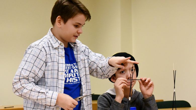 Ryker Selnekovic, left, and Killian Radel, both seventh-grade students in the Brookville Area School District, work to perfect their bridge during the Mystery Architecture activity at the 2019 regional Science Olympiad. 