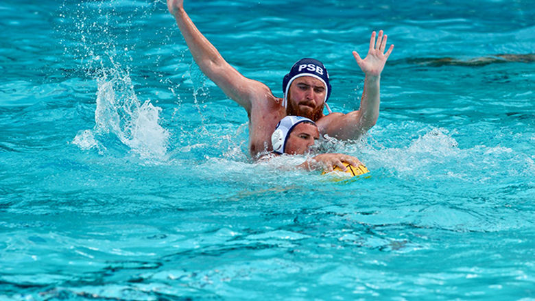 A Penn State Behrend water polo player battles for the ball.
