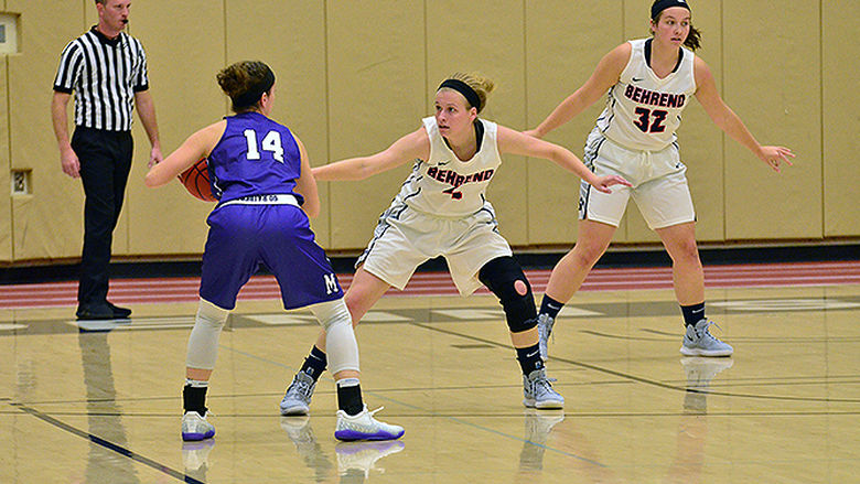 A Penn State Behrend women's basketball player defends the back court as an opposing player approaches.