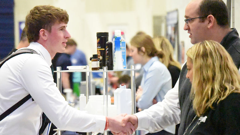 A student shakes hands with a potential employer during a Behrend Career and Internship Fair