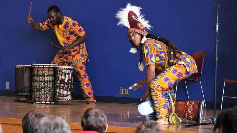 Two drummers perform traditional African music on a stage at Penn State Behrend's McGarvey Commons.
