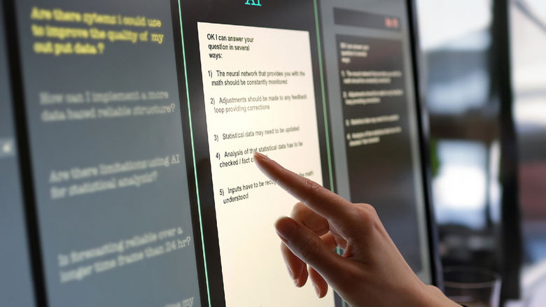 A hand points to a touchscreen displaying a response from an AI chatbot