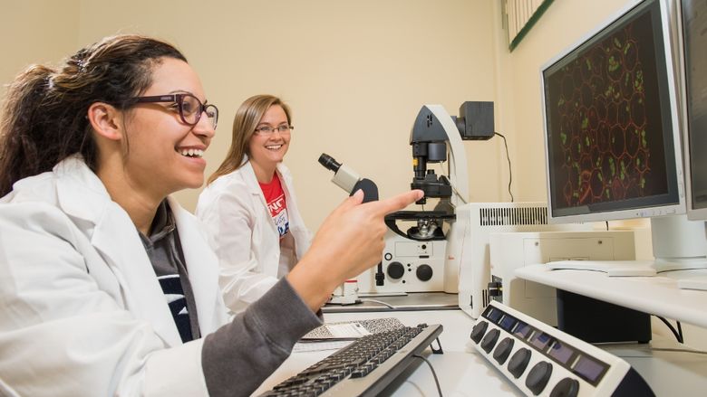 Two students work on the confocal microscope at Penn State Behrend