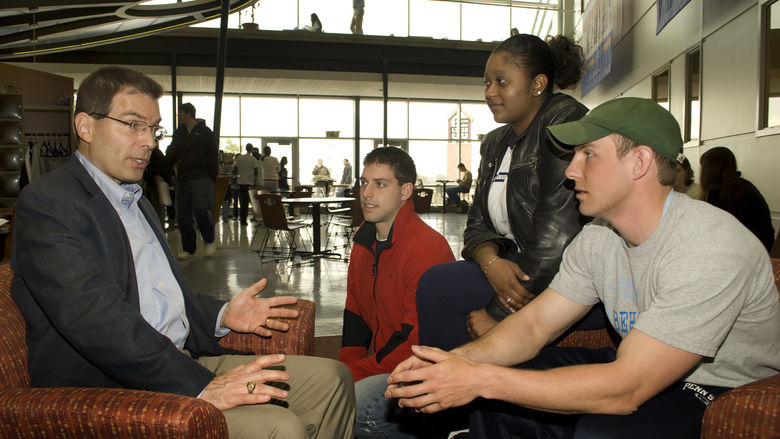 Students talk with an alumnus at the Black School of Business at Penn State Behrend.