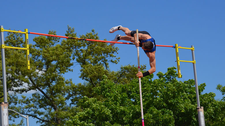 Track and field athlete attempts a pole vault.