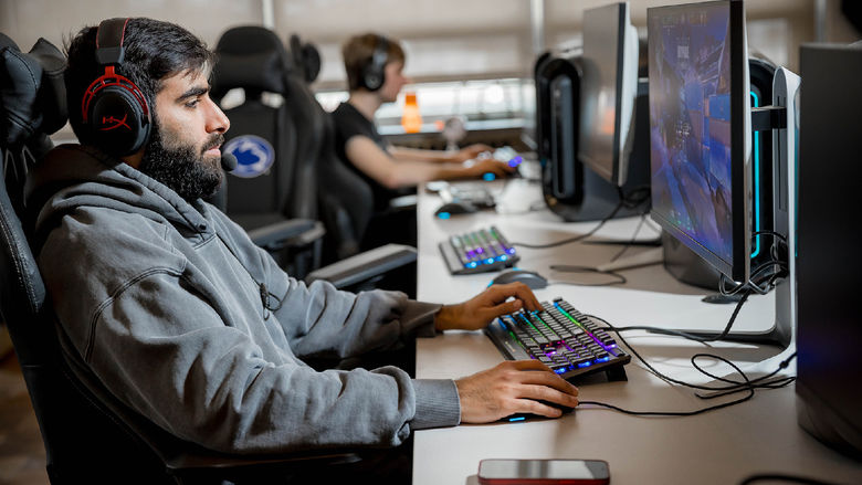 A male student plays a videogame in Penn State Behrend's esports lounge.