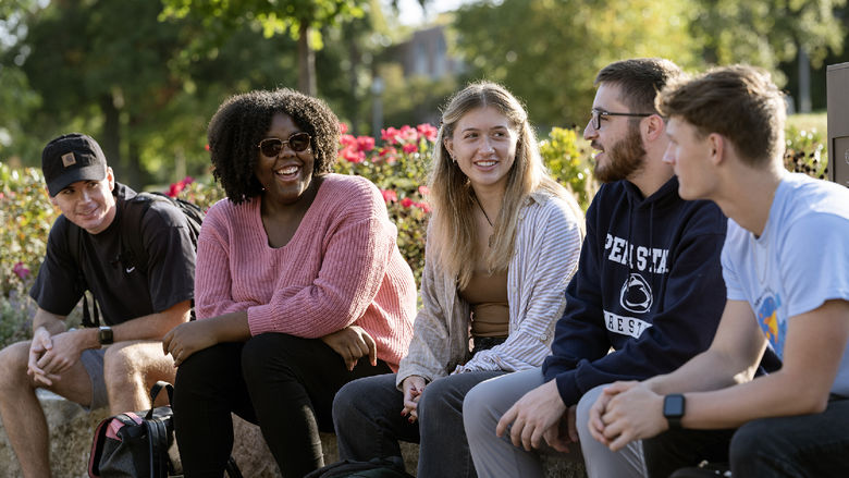 Students talk while sitting outside at Penn State Behrend.