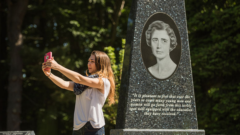 Penn State Behrend student Olivia Narciso snaps a selfie in front of the Mary Behrend Monument.
