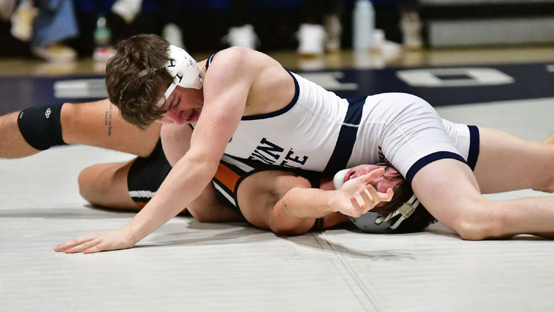 A Penn State Behrend wrestler pins his opponent.