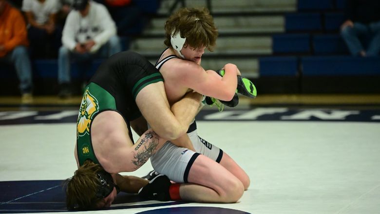 A Penn State Behrend wrestler gains leverage on an opponent, who is upended.