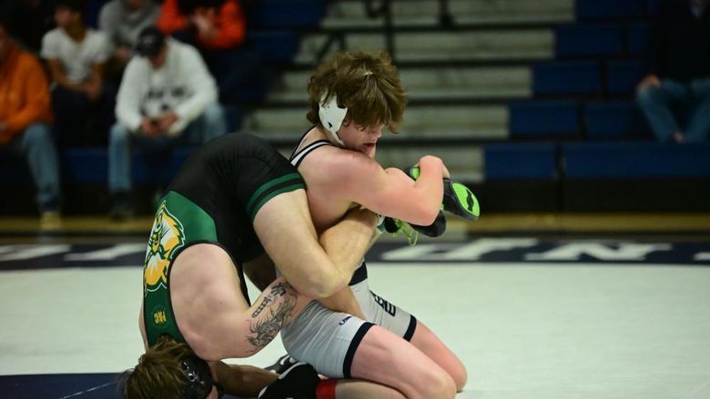 A Penn State Behrend wrestler gains leverage on an opponent, who is upended.