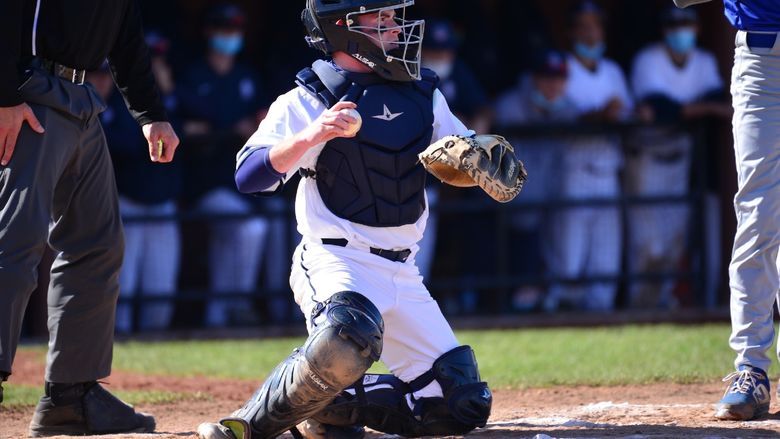 A catcher for the Penn State Behrend baseball team throws the ball.