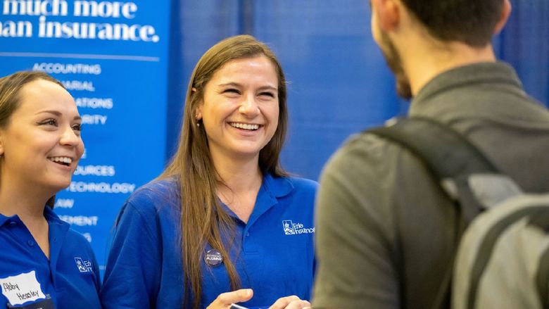 Two female corporate recruiters talk with a student during Penn State Behrend's fall career fair.