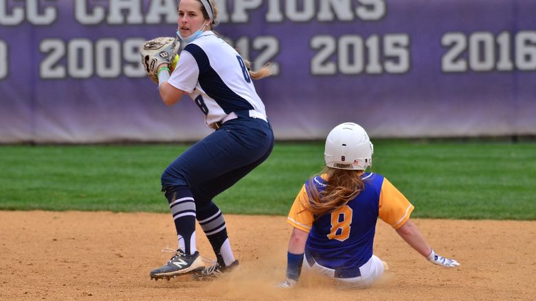 A Penn State Behrend softball player prepares to throw the  ball after a runner is tagged out.