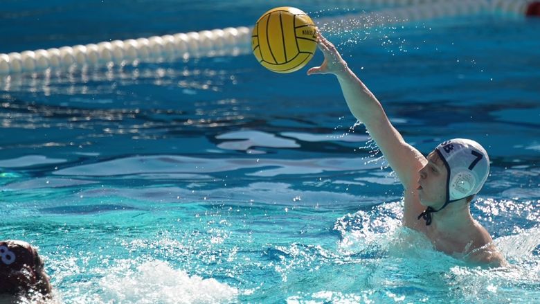 A Penn State Behrend water polo player throws the ball.