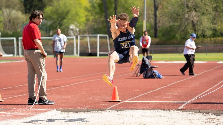 A Penn State Behrend student-athlete competes in the long jump at an outdoor track.