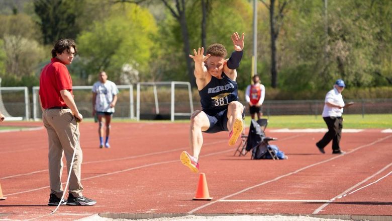 A Penn State Behrend student-athlete competes in the long jump at an outdoor track.
