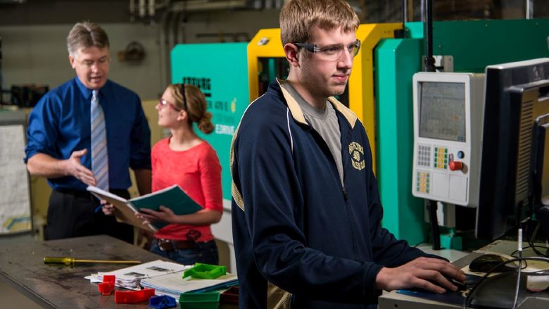 Two students and a faculty member work in Penn State Behrend's plastics engineering technology lab.