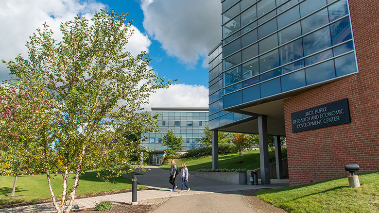 Two students walk in front of the Burke Center at Penn State Behrend.
