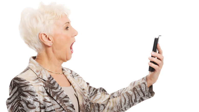 Image of an older woman looking at a phone.