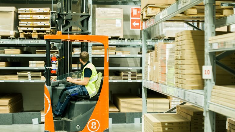 A worker moves product in a warehouse distribution center.