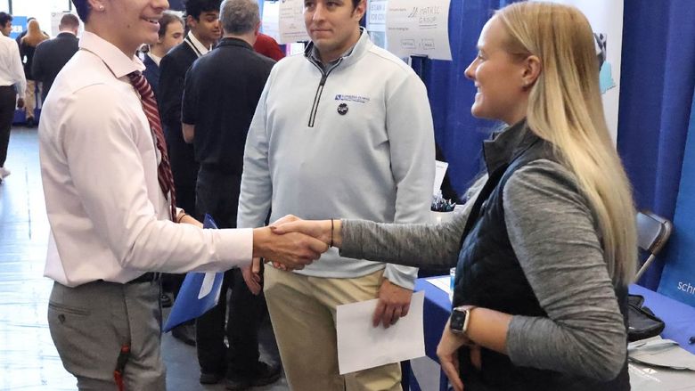 A recruiter shakes hands with a student at Penn State Behrend's career fair.