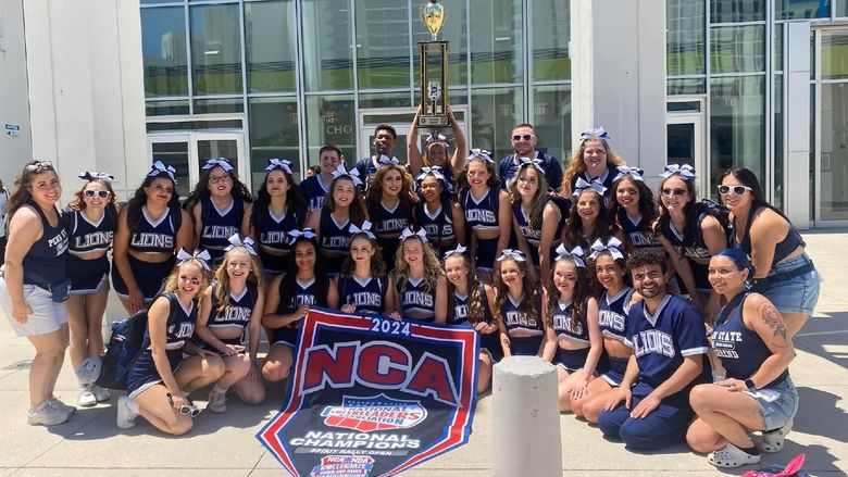 The Penn State Behrend cheer team poses with the trophy after winning the national title.