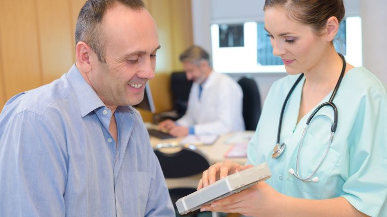 A medical assistant gets information from a patient.