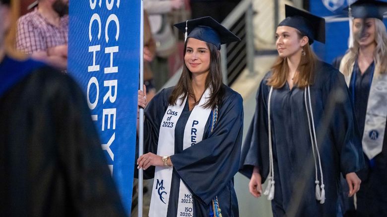 A student marshal enters Erie Insurance Arena during Penn State Behrend's spring 2023 commencement ceremony.