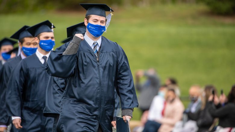 Penn State Behrend graduates celebrate as they leave the field after commencement.