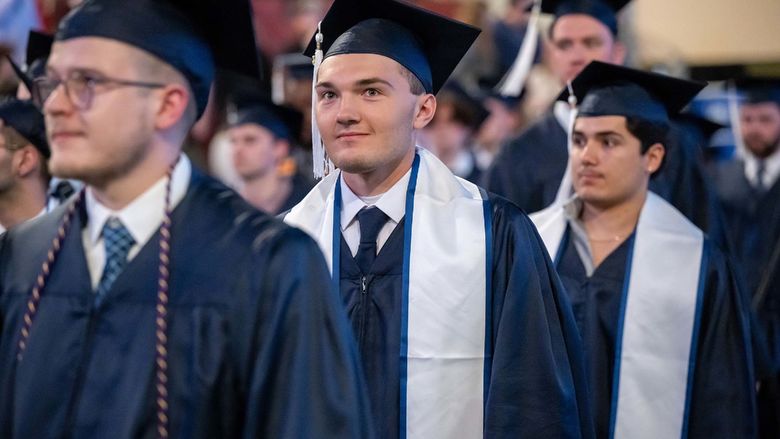 Graduates process into Erie Insurance Arena at the beginning of Penn State Behrend's spring 2023 commencement ceremony.
