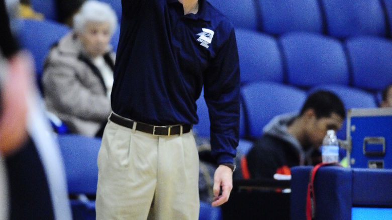 Penn State Behrend men's basketball coach Dave Niland signals to his team from the edge of the court.