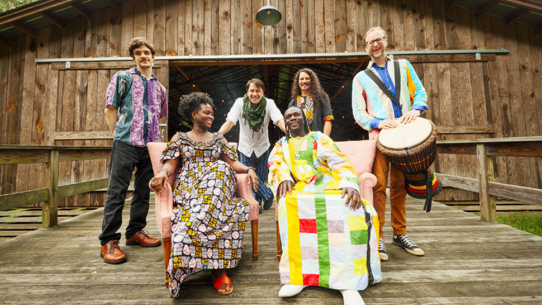 The musician Diali Cissokho and his band Kaira Ba sit on a porch.
