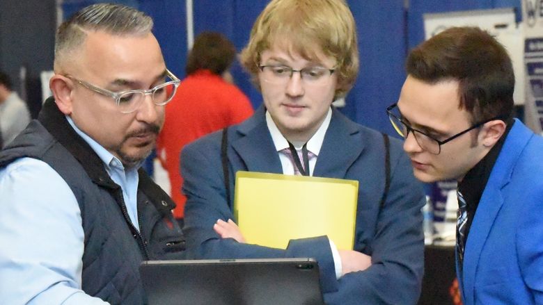 Two students talk with a recruiter at Penn State Behrend's Career and Internship Fair.